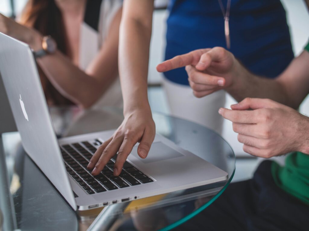 Image of various consultants working in an office, no faces seen, mostly hands and a laptop