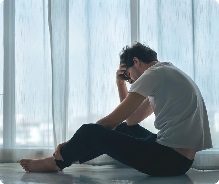 a man in a room worried hunched